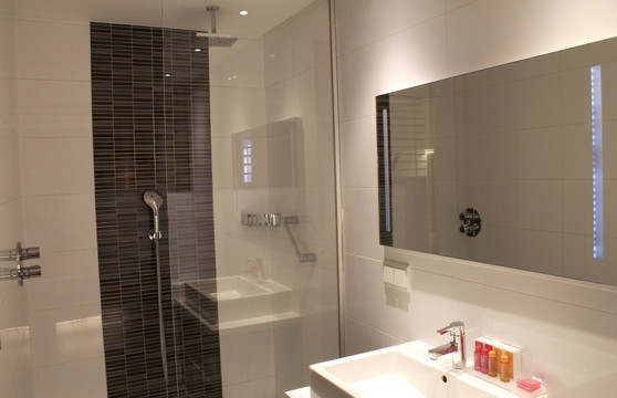 Badkamer met bad en douche