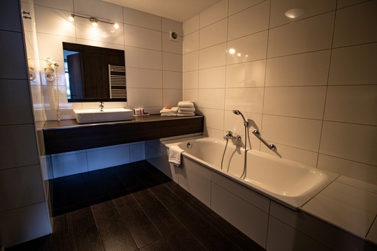 Badkamer met bad en douche