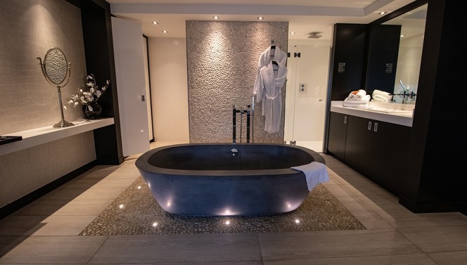 Open badkamer met bad en douche