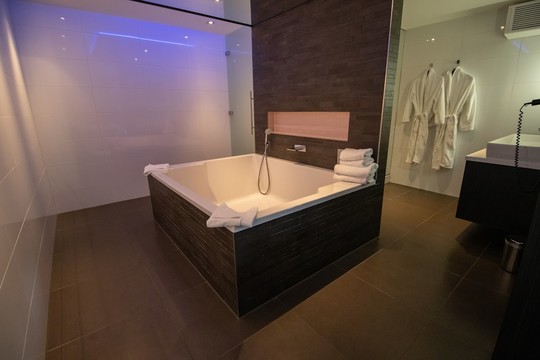 Badkamer met bad en douche